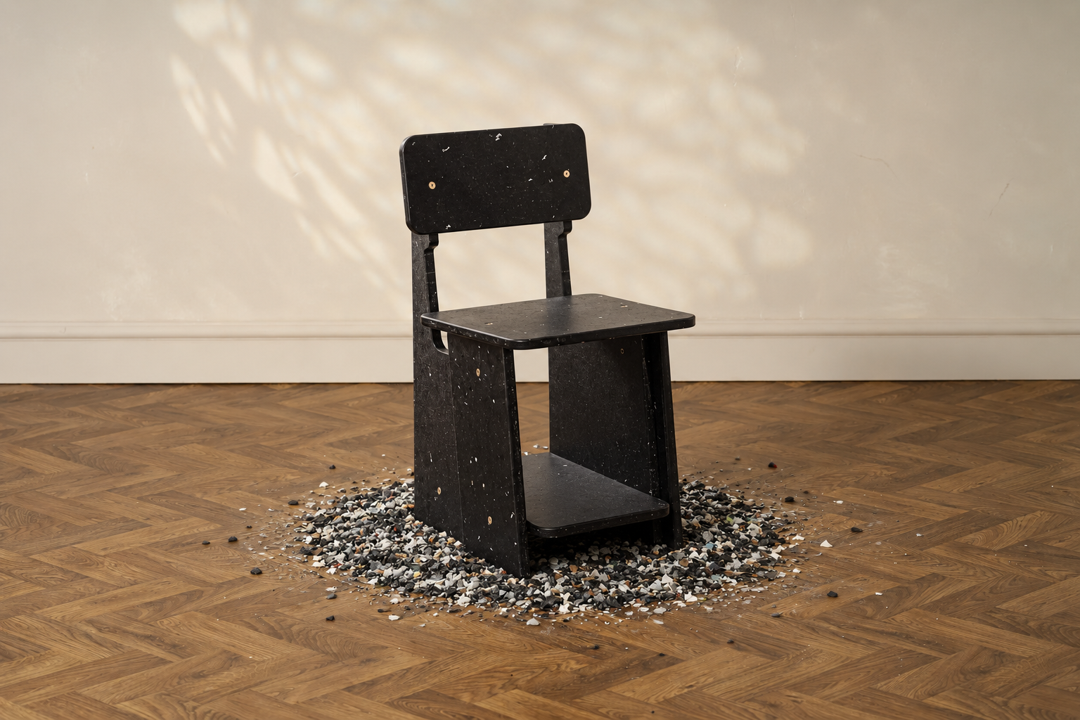 MadeBy recovered-plastic chair standing on a ring of shredded plastic flake in a sunlit room with herringbone parquet flooring