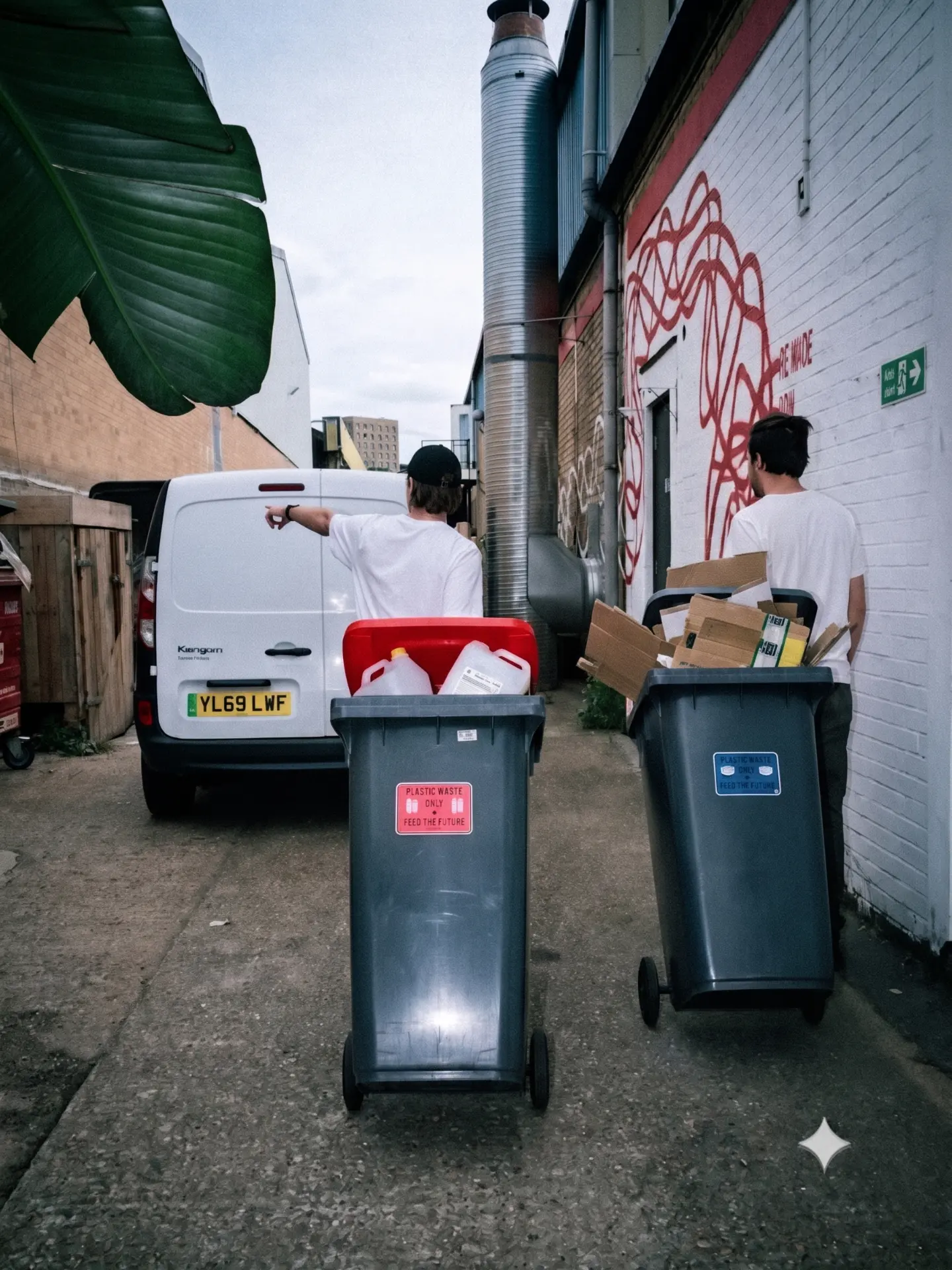 Sorted plastic and cardboard bins being handed over beside the MadeBy van