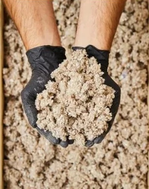 Gloved hands holding recovered cardboard fibre