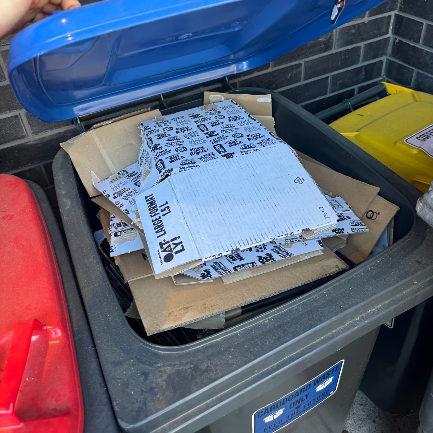A bin of flattened cardboard and drinks cartons collected for recovery