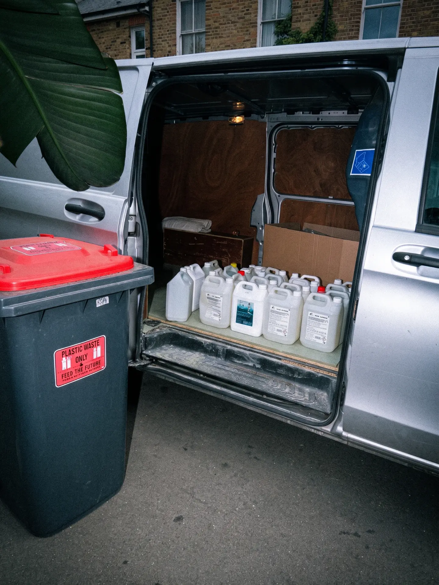 Van loaded with recovered cleaning-product bottles next to a plastic waste bin