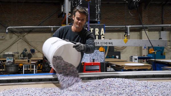 A specialist laying up raw shredded material into a mould at the workshop