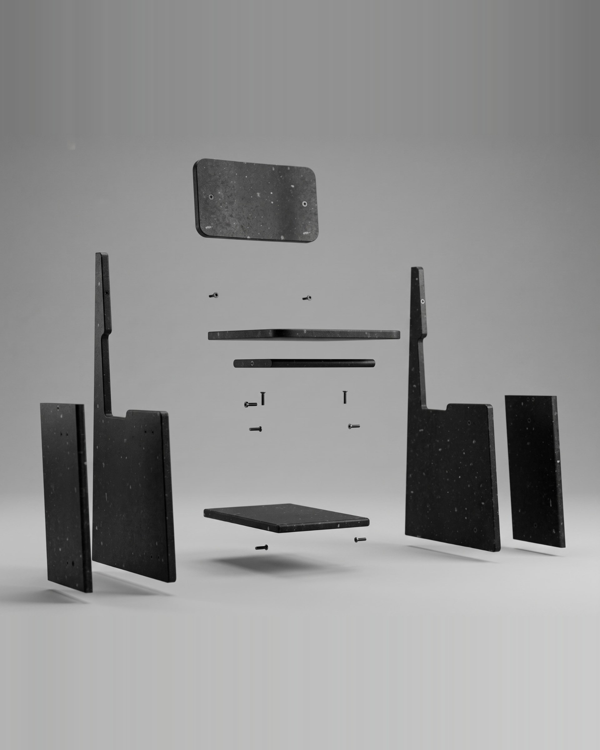 Exploded view of a MadeBy recovered-material chair showing its flat panels, footrest and black fixings